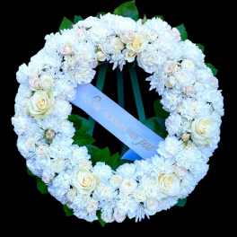 White floral wreath with roses and chrysanthemums on a black background