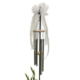 White ribbon-tied wind chime hanging on a black stand