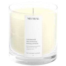 Cream-colored candle in a clear glass jar with a labeled front