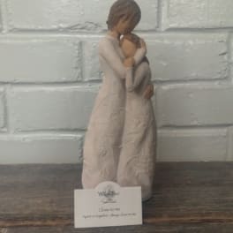 Two figurines embracing, with a small card in front