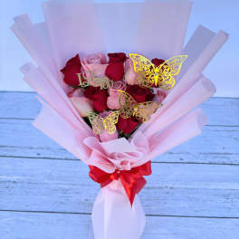 Pink and red rose bouquet with butterfly picks and a red ribbon
