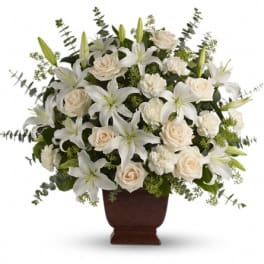 White lilies and cream roses arranged in a brown urn