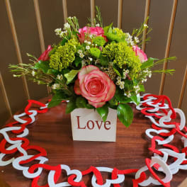 Pink roses and green chrysanthemums in a white box with a heart garland