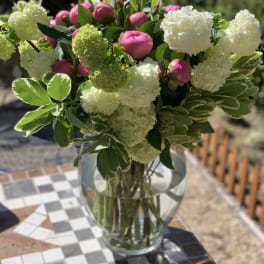 Pink peonies and white hydrangeas in a clear glass vase