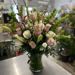 Pink and white rose bouquet with lilies in a glass vase