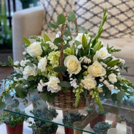Basket arrangement of white roses, lilies, and carnations