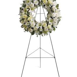 White floral wreath on a black standing easel