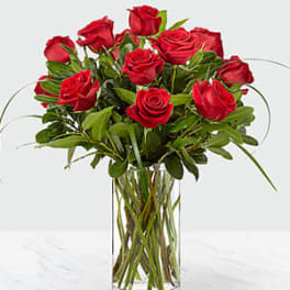 Red roses arranged in a clear glass vase