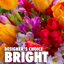 Close-up of a bright mixed bouquet with yellow tulips and assorted pink, red, and purple flowers.