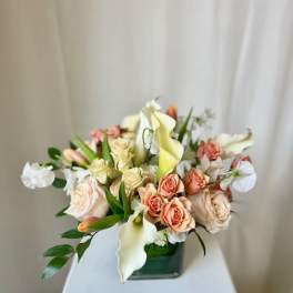 Bouquet of peach and white flowers in a dark vase