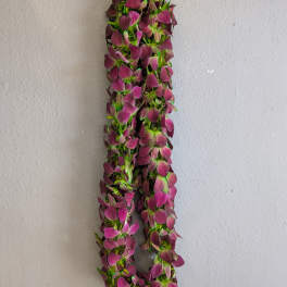 A hanging garland of purple flowers against a plain wall