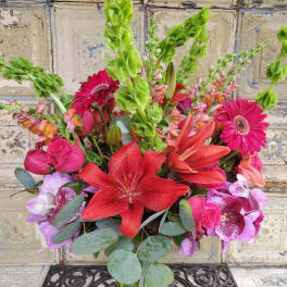 Mixed bouquet with red lilies, pink roses, gerbera daisies, and purple orchids