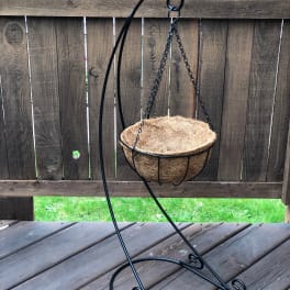 Empty hanging coco liner basket on a black metal stand