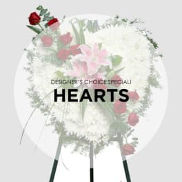 Heart-shaped standing spray with white flowers, pink lilies, and red roses