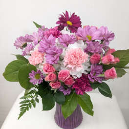 Pink and purple mixed bouquet in a ribbed purple vase