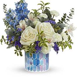 Blue and white floral arrangement in a mosaic glass vase