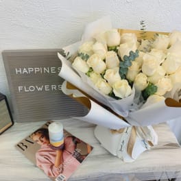 Bouquet of cream roses wrapped in white paper