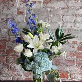 Blue and white floral arrangement in a clear glass vase