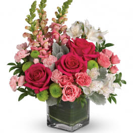 Pink roses and white alstroemeria in a square glass vase