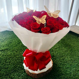 Bouquet of red roses wrapped in white paper with a red bow
