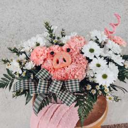 Pink floral arrangement with a pig face centerpiece and white daisies