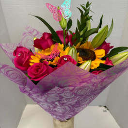 Bouquet of pink roses and yellow sunflowers wrapped in purple paper