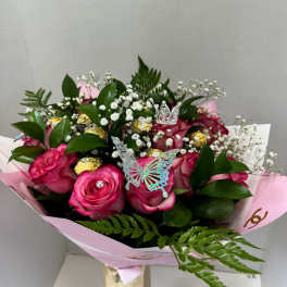 Pink rose bouquet with baby's breath, gold chocolates, and butterfly picks