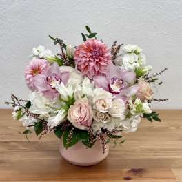 Pink and white floral arrangement in a blush vase