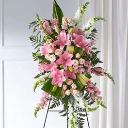 Tall pink and white floral standing spray on a black easel