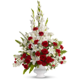Tall red and white floral arrangement in a white vase
