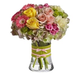 Mixed bouquet of roses, gerbera daisies, and hydrangeas in a glass vase