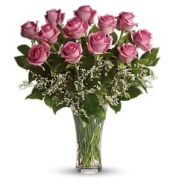 Pink roses arranged in a clear glass vase with white filler flowers