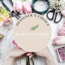 Floral design tools and pink tulips around a round sign