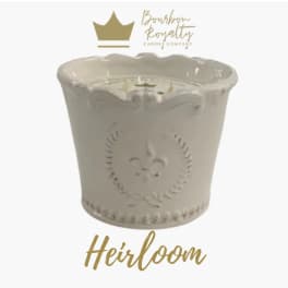 Cream ceramic candle jar with a scalloped rim and gold logo text