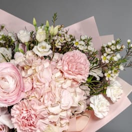 Bouquet of pale pink and white flowers wrapped in blush paper