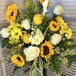 Bouquet of yellow sunflowers and white roses in a glass vase