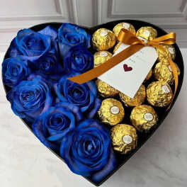 Heart-shaped box with blue roses and gold-wrapped chocolates