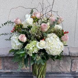 Bouquet of pale pink roses and white hydrangeas in a clear glass vase