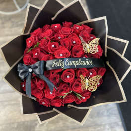 Red rose bouquet with black wrapping, ribbon, and butterfly decorations