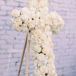 White floral cross on a wooden easel