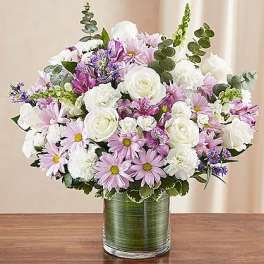 Bouquet of white and lavender flowers in a green glass vase