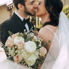 Bride and groom holding a pale rose bouquet