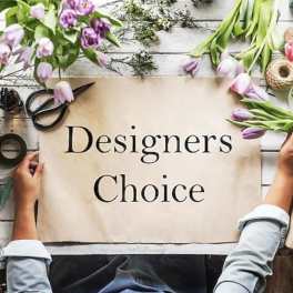 Tulips and floral supplies arranged around a sign reading Designers Choice