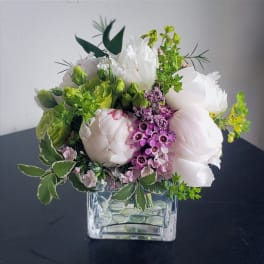 White and pink bouquet in a clear square glass vase