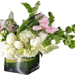 White and pink flowers arranged in a square glass vase
