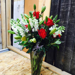 Red roses and white snapdragons in a clear glass vase