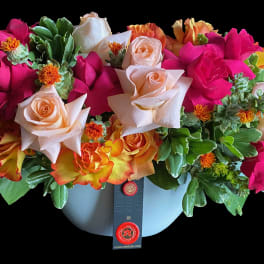 Mixed roses in a light blue hatbox-style container