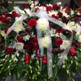 Large red and white floral spray with a sheer ribbon bow