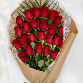 Bouquet of red roses wrapped in brown paper with lace trim