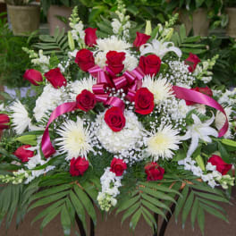 Large red and white floral spray with pink ribbon